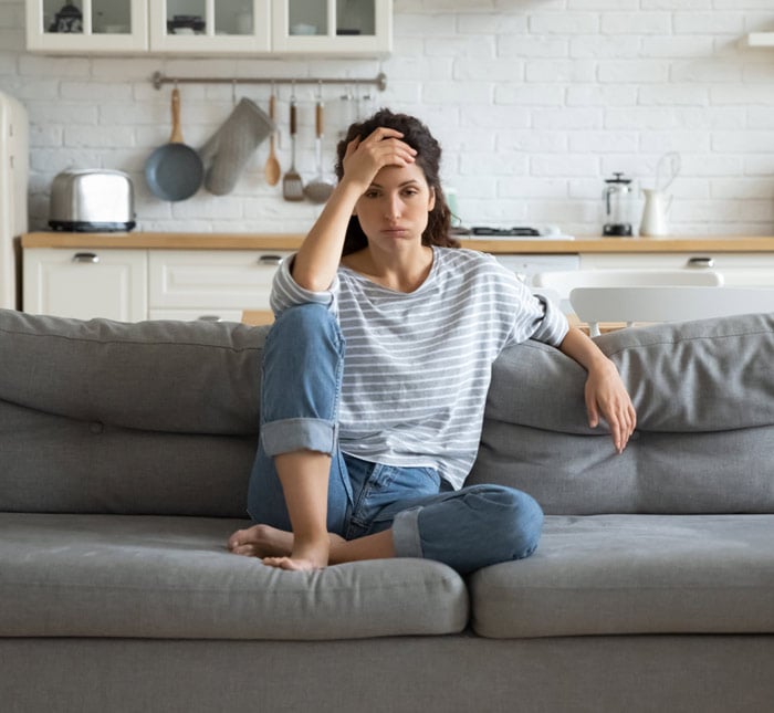 Depressive Frau sitzt auf einer Couch